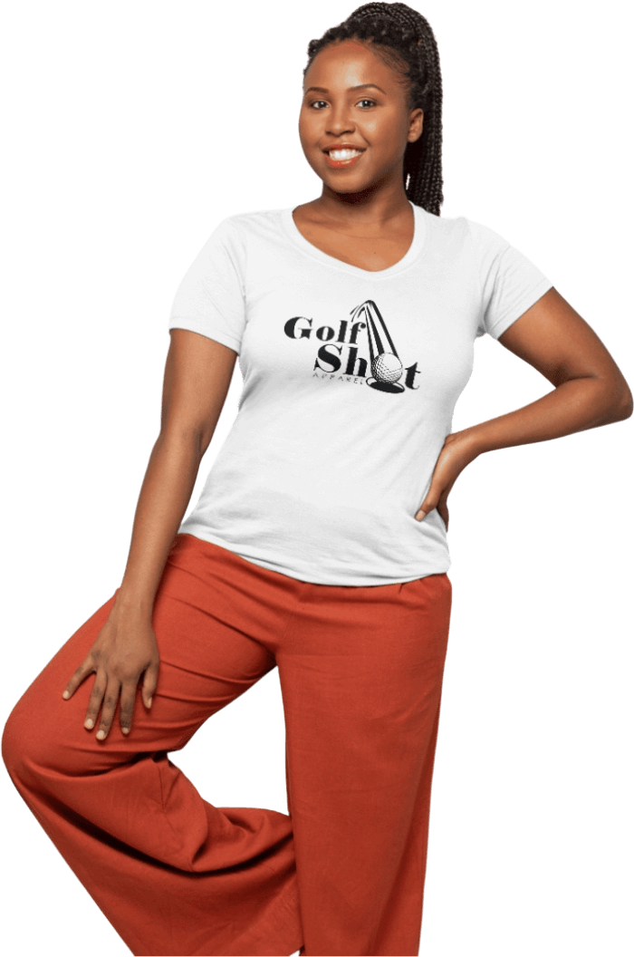 A woman in a white "Golf Shot" T-shirt and orange pants poses with one hand on her hip and the other resting on her thigh.